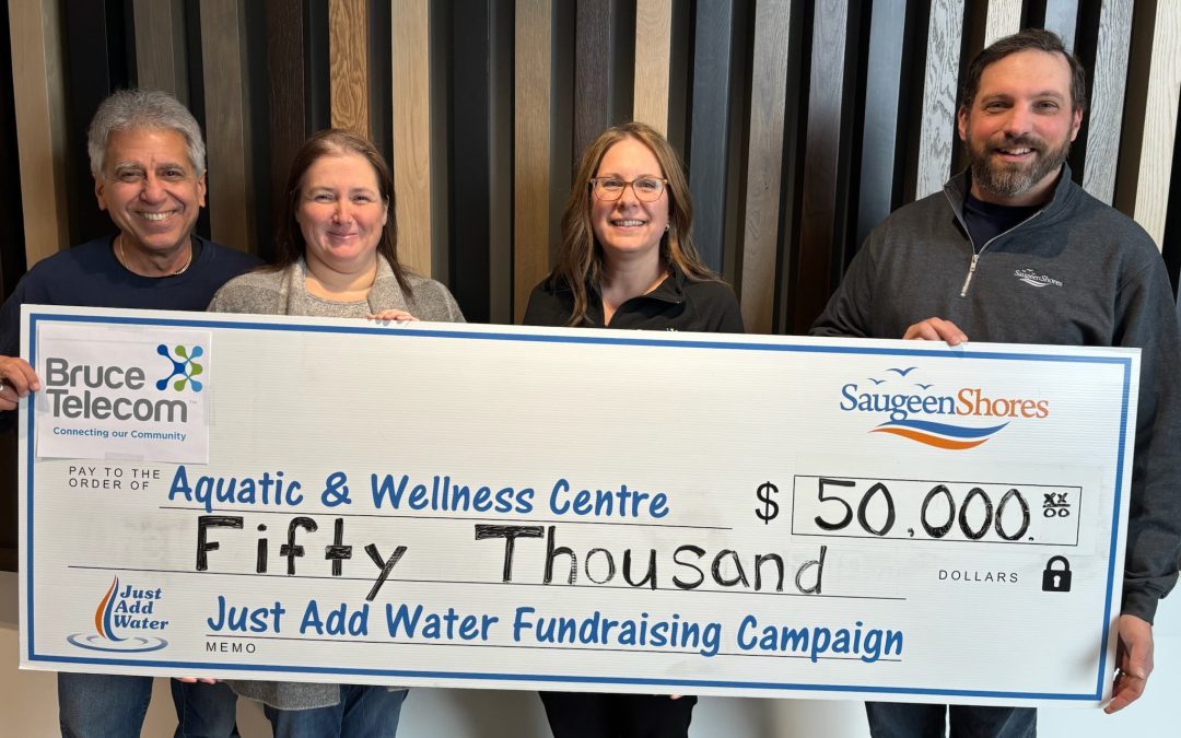 Group of people holding a large cheque